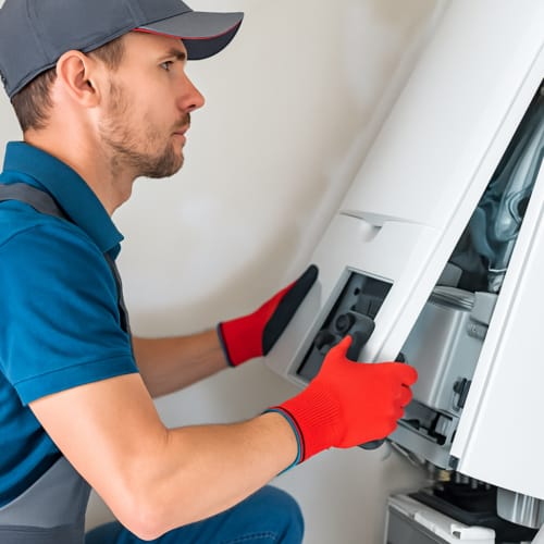 HVAC technician inspecting and adjusting a residential furnace unit during maintenance