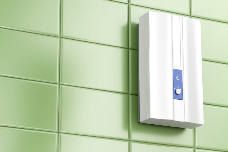 Compact tankless water heater mounted on a light green tiled wall